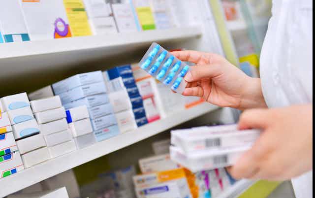 A pharmacist peruses medicines.