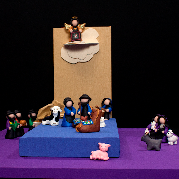 A simple Nativity set shows figures in hats and bonnets without their facial expressions painted.