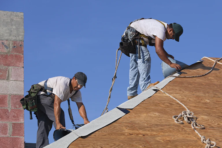 two construction workers on a roof