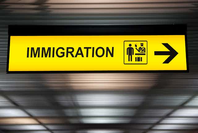 A yellow sign with the word: immigration