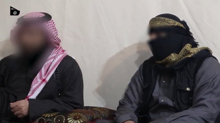 رجلان يرتديان أغطية للرأس وأردية وجوههم غير واضحة.