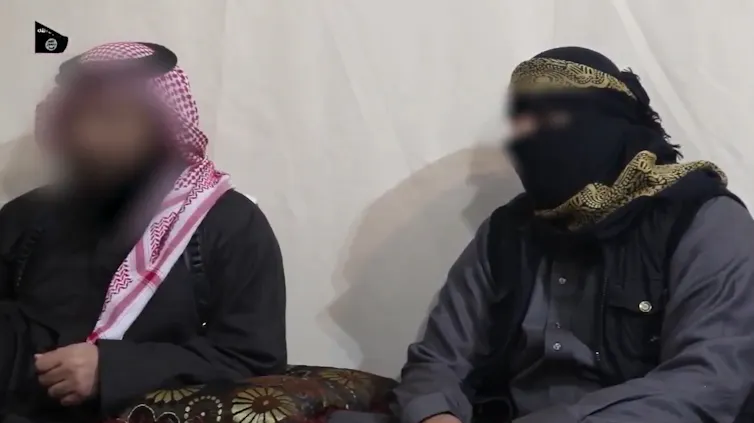 Two men in headdresses and robes with faces blurred out.