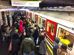 A busy underground train platform with passengers about to board a train.