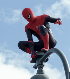 Spider-Man perched atop a street light in Spider-Man: No Way Home