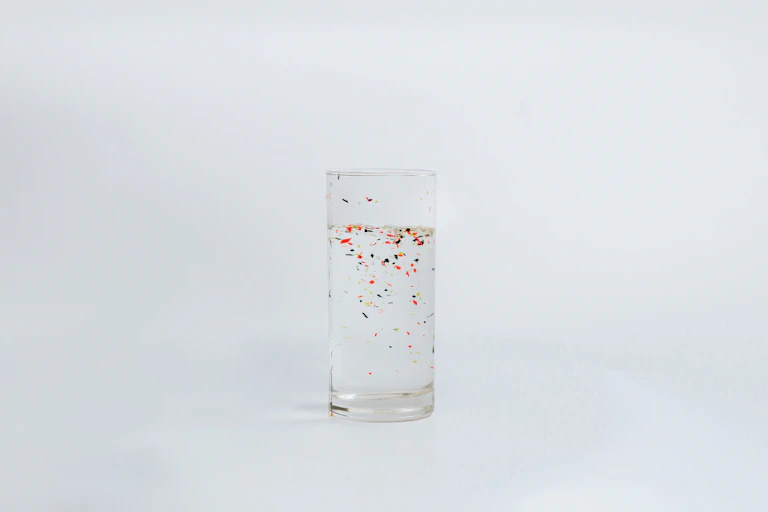 Vaso con partículas de plástico en su interior