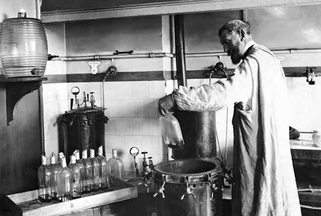 Louis Pasteur dans son laboratoire, en train de travailler avec diverses fioles