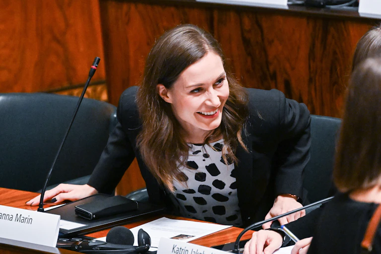 Finland's Sanna Marin smiles and leans over her podium during a meeting of the Nordic Council