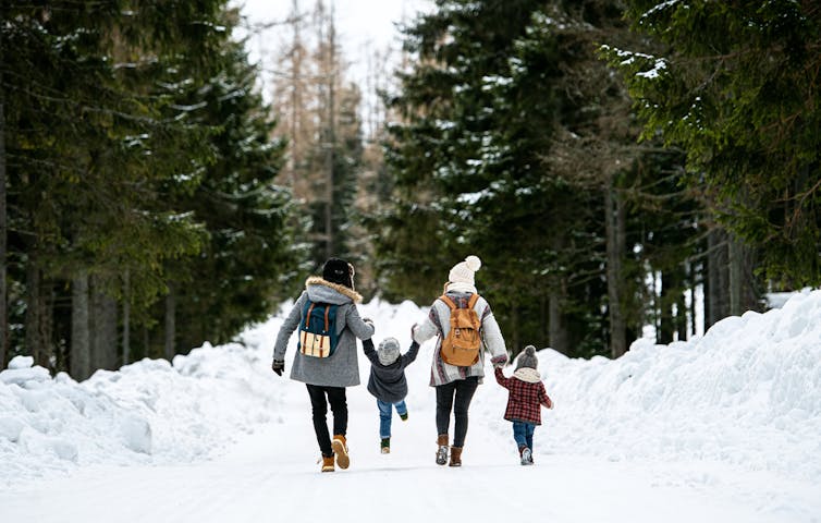خانواده ای که در برف قدم می زنند