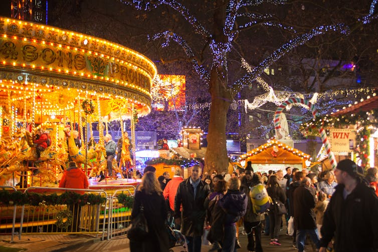 An evening shot of Winter Wonderland lit up by artificial lights. A carousel to the left.