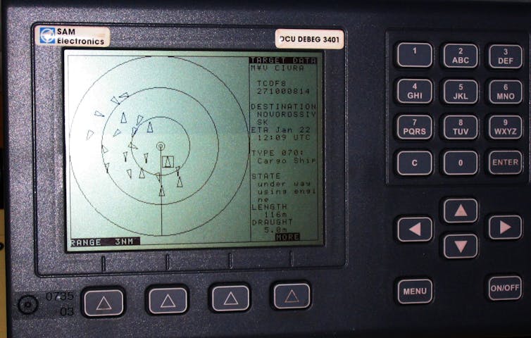 An electronic display shows triangles representing nearby ships within concentric circles.