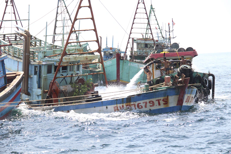 A boat founders, nearly swamped, as water sprays in from another boat