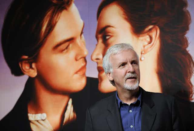 James Cameron stands in front of a huge poster of Rose and Jack, lead characters in Titanic