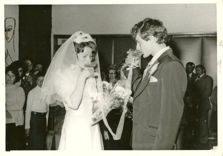 An old photo from around 1975 shows newlyweds drinking together at their wedding.