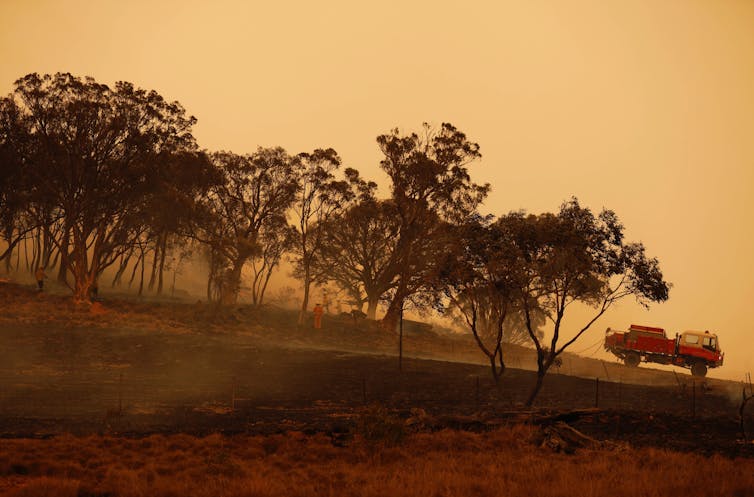 fire truck parked as firefighters battle blaze