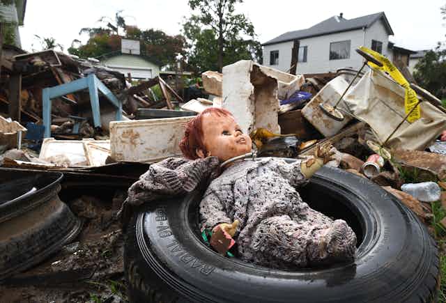 doll lies in pile of flood-damaged refuse