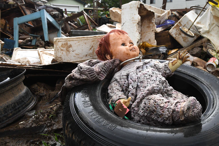 doll lies in pile of flood-damaged refuse