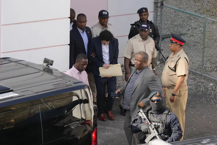 FTX's founder Sam Bankman-Fried, centre, is escorted from court Nassau, Bahamas on December 19 2022. The US government is seeking his extradition to face fraud charges.