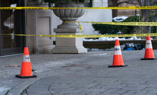 traffic cones and police tape seal off the entrance to a building