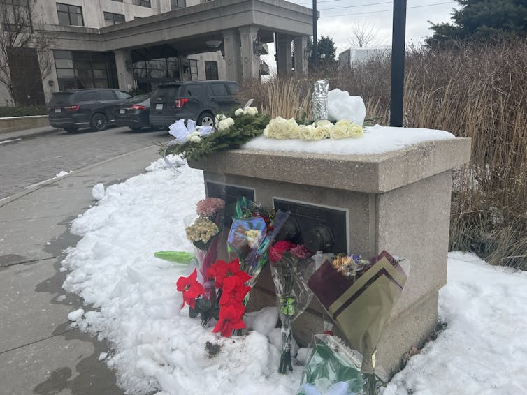 bouquets in the snow near a building entrance