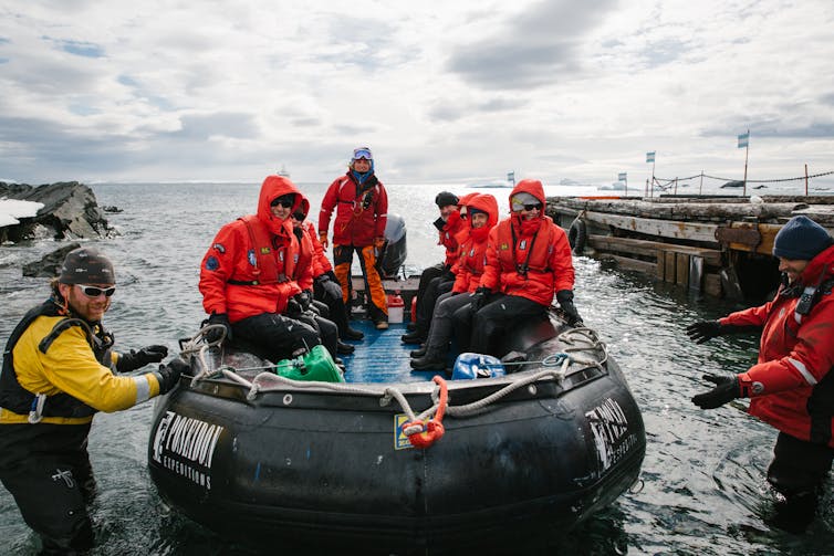 people in red jackets on rubber boat