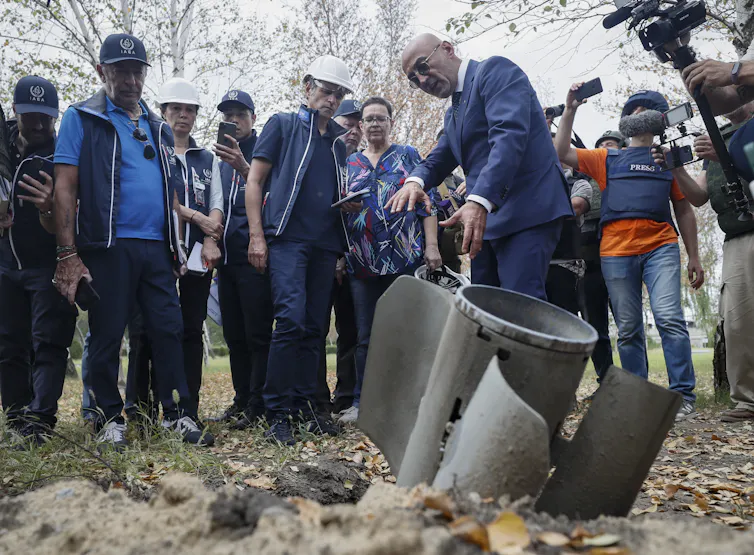 Officials of the International Atomic Energy Agency (IAEA) inspect a shell casing half buried in the ground at Zaporizhzhia nuclear power plant in southeastern Ukraine.