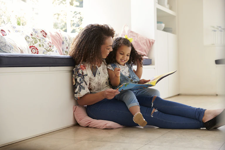 Une femme lit une histoire à une petite fille
