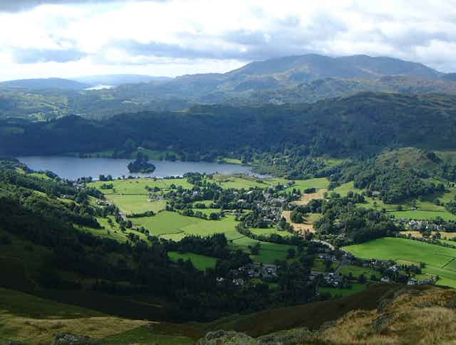 A lake surrounded by green fields and hills
