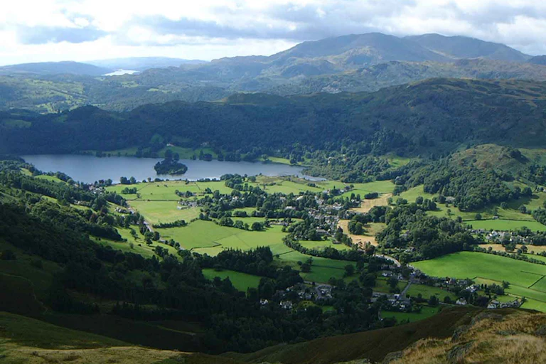 A lake surrounded by green fields and hills