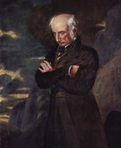 Portrait of a man with arms folded, standing on a rocky point