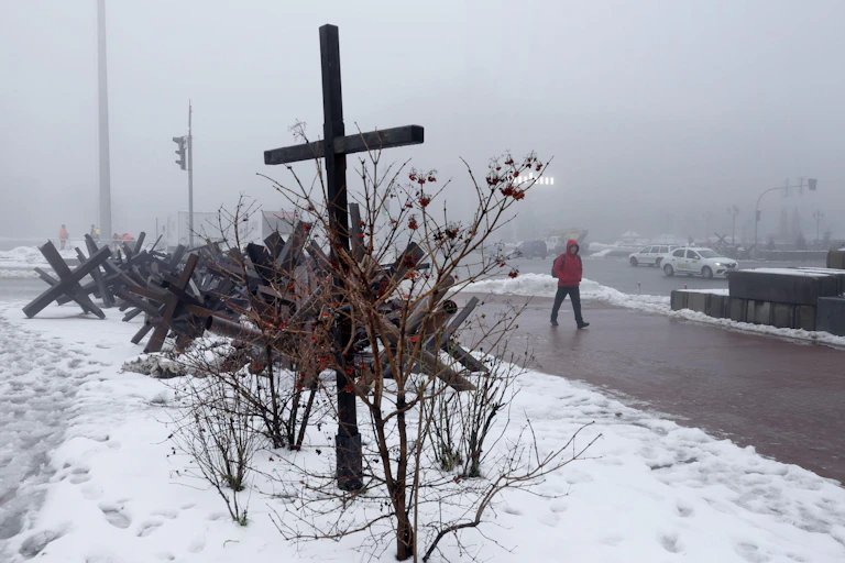 A cross in the snow on a street in Kyiv, Ukraine, December 2022.