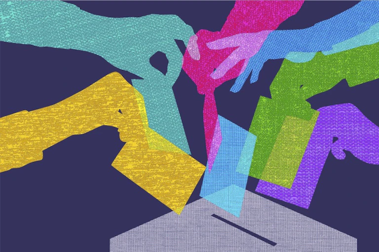 Multi-colored hands are seen putting colorful cards into a ballot boxx.