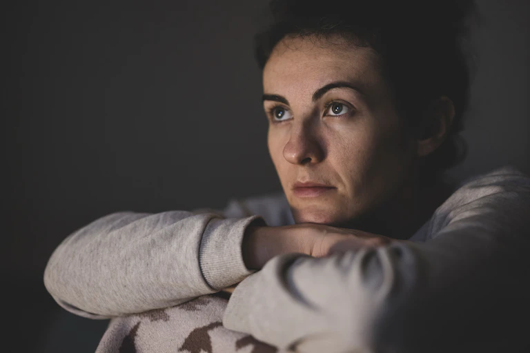 Woman sits with arms folded