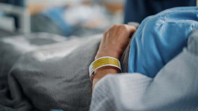Person with hospital bracelet lying in hospital bed