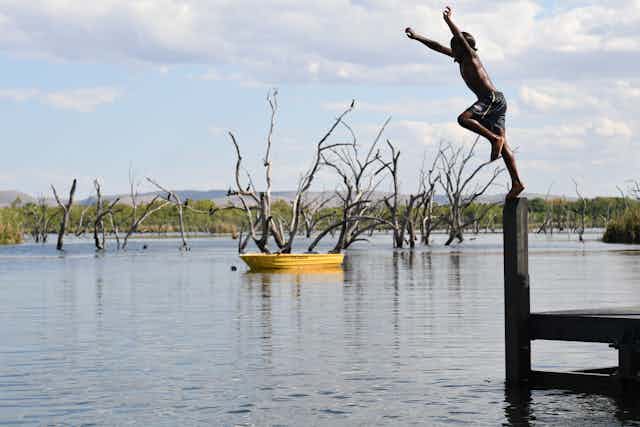 Boy jumping into a lake