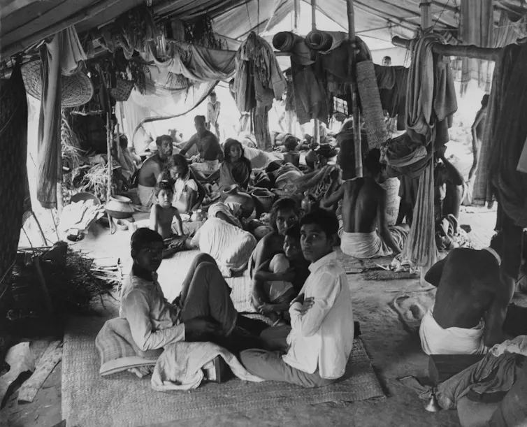 A tent crowded with people and their belongings