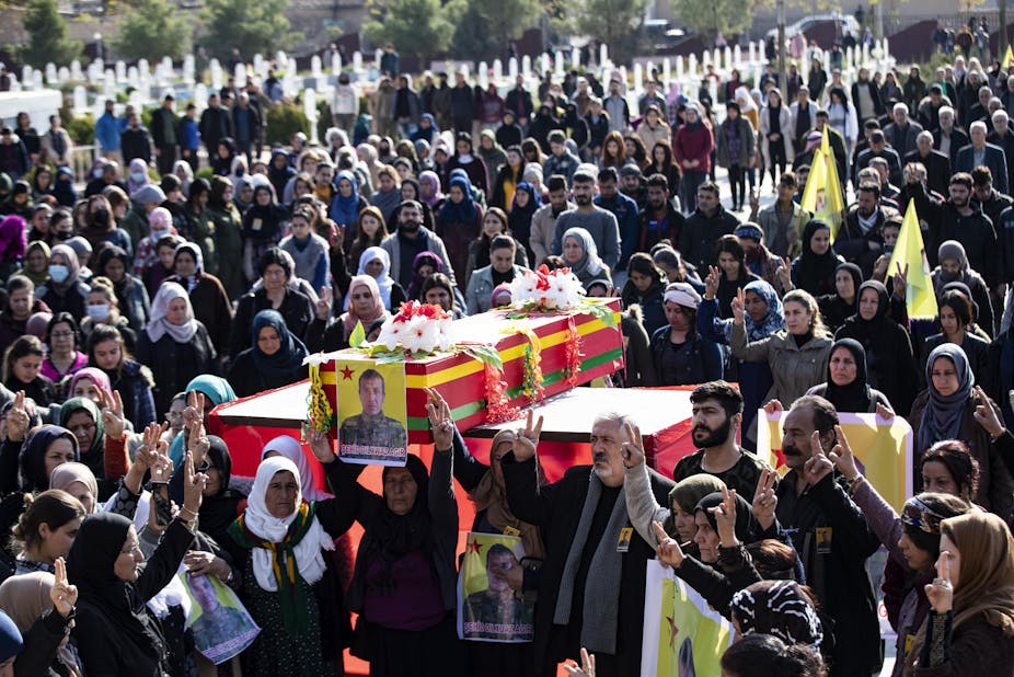 Cercueil d'un combattant porté par une foule de plusieurs dizaines de personnes