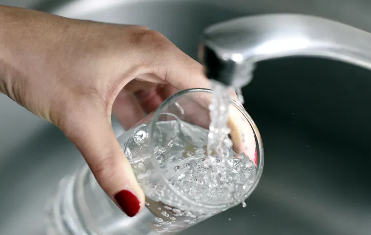 Une personne prenant de l’eau du robinet dans un verre