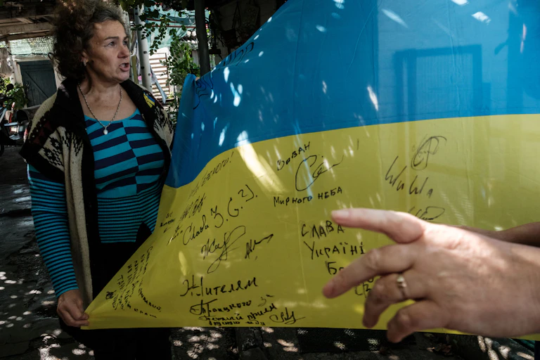 Une femme montre un drapeau ukrainien portant des signatures