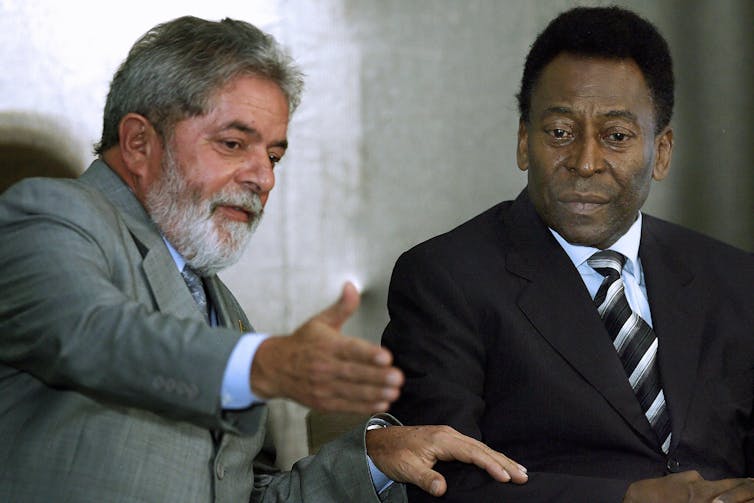 two men in suits chat with one gesticulating