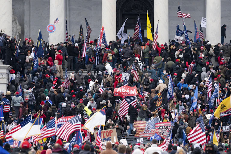 Thousands of people crowd on the steps of the U.S. Capitol.