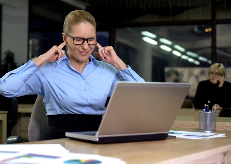 Femme se bouchant les oreilles sur son lieu de travail