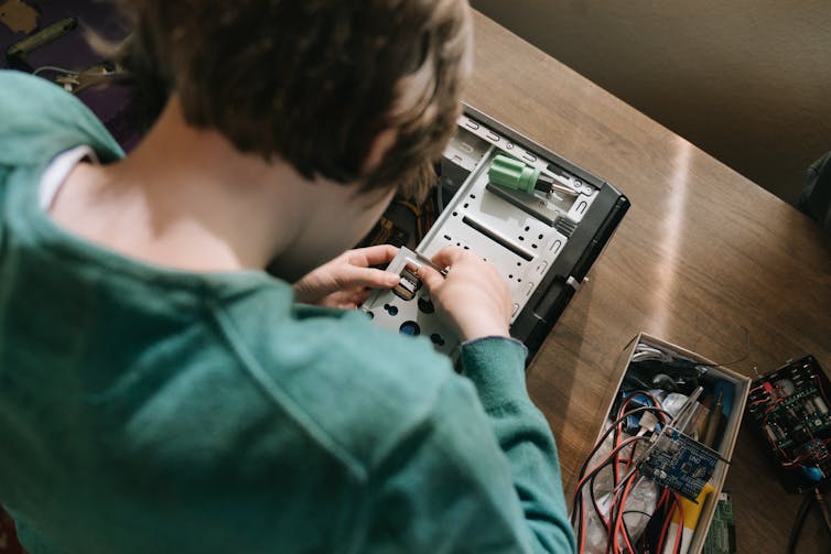 Un homme répare un circuit imprimé