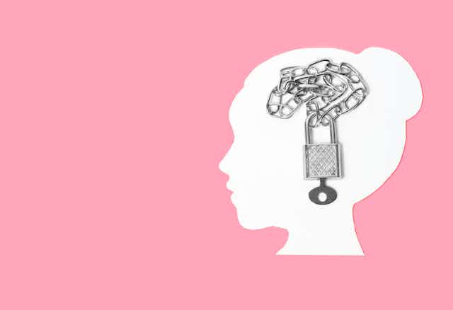 Silhouette of woman's head with chain and padlock superimposed on it.