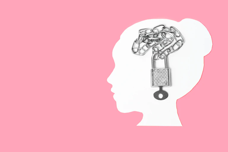 Silhouette of woman's head with chain and padlock superimposed on it.