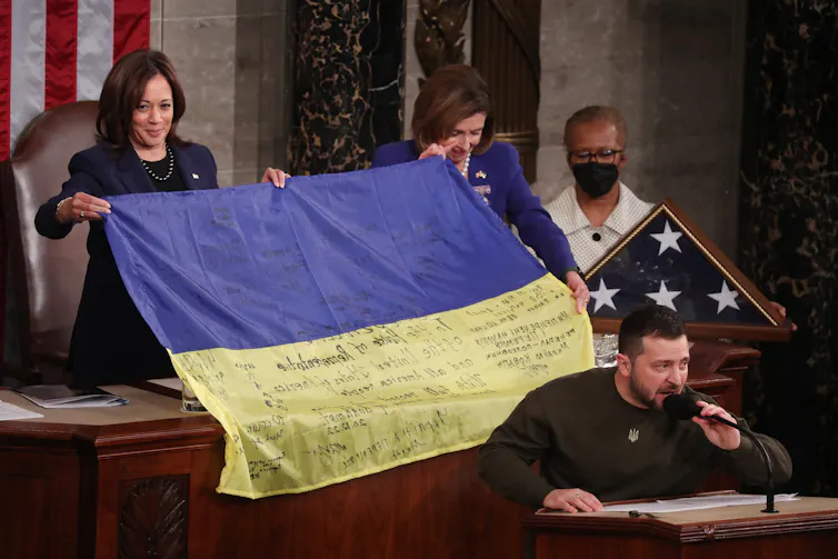 Ukraine president, Volodymyr Zelensky, speaks to the US Congress as US vice-president, Kemala Harris, holds up a Ukrainian glag behind him.