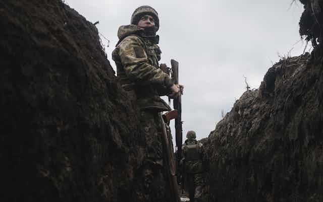 A Ukrainian soldier stands on sentry duty in a trench in Bakhmut, eastern Ukraine.