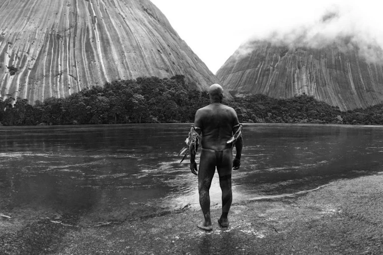 Un hombre indígena observa la naturaleza a su alrededor.