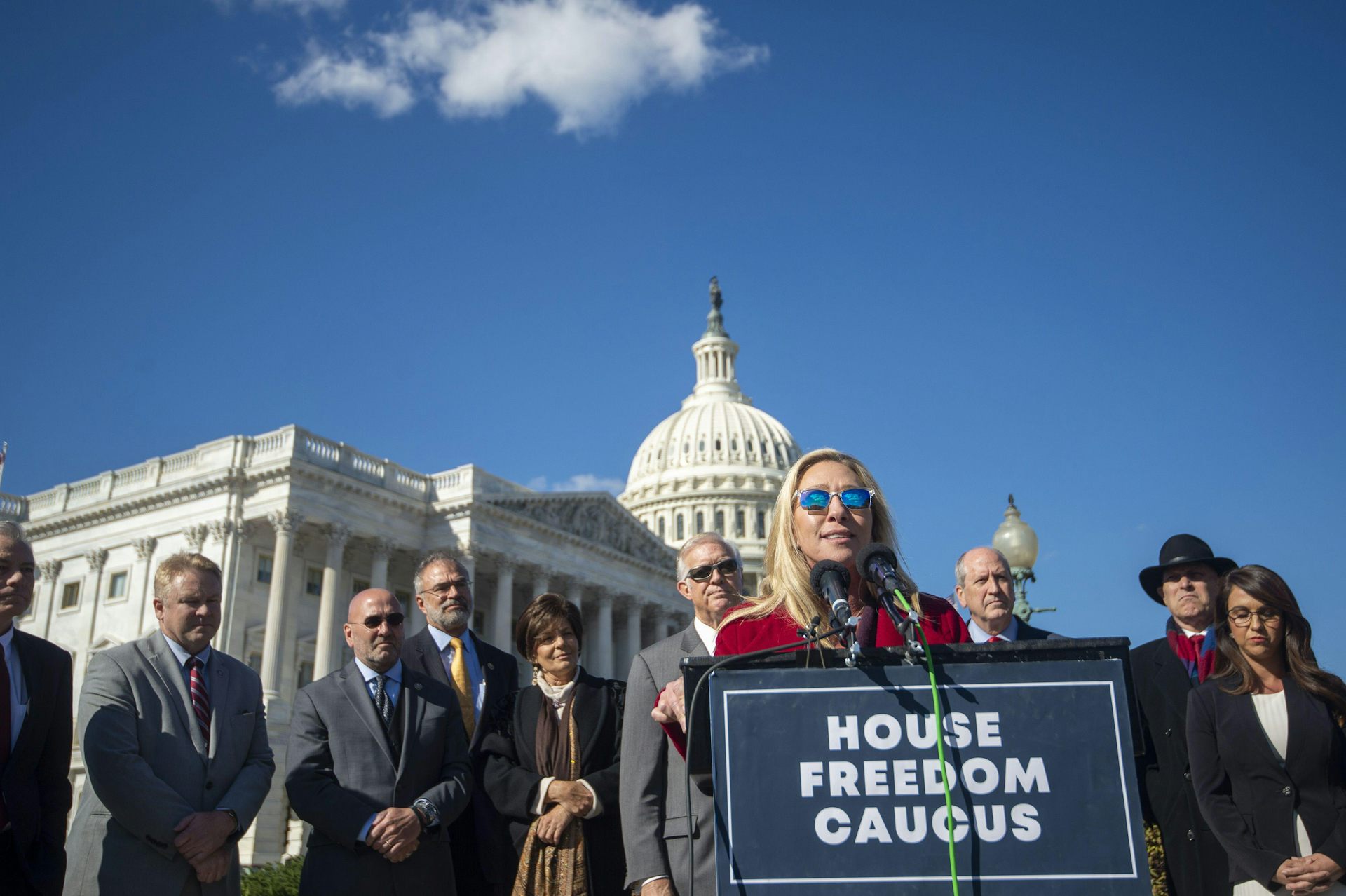 A woman at a podium with the Capitol building behind her.