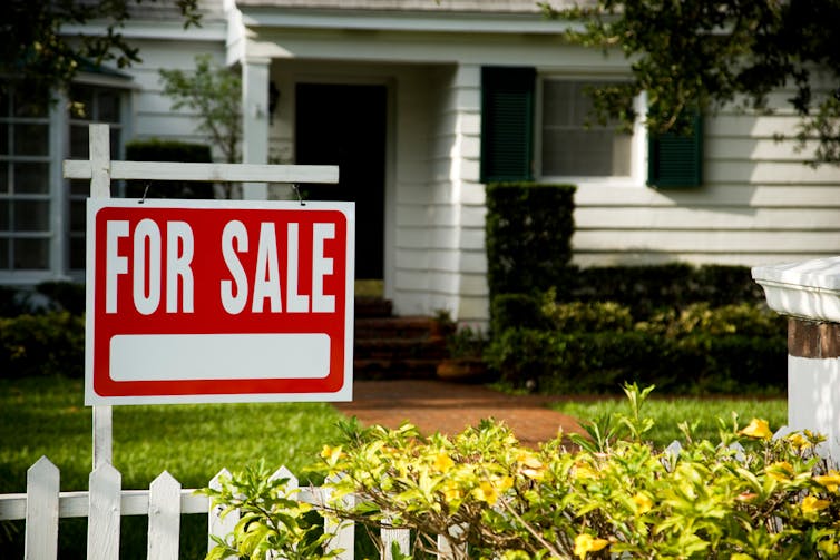 A for sale sign outside a family house.