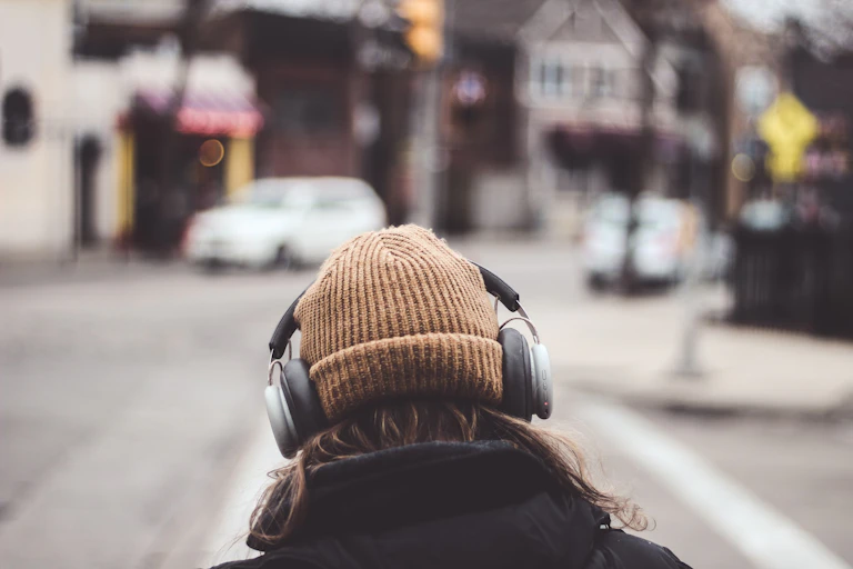 Una mujer de espaldas escucha unos auriculares.